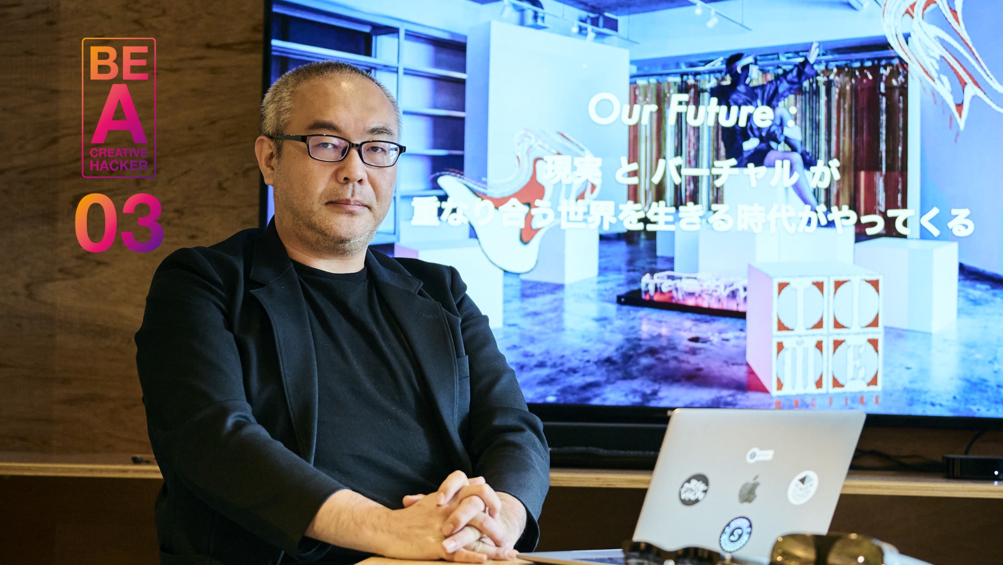 Portrait of Masahiro Yamaguchi wearing glasses and a dark jacket