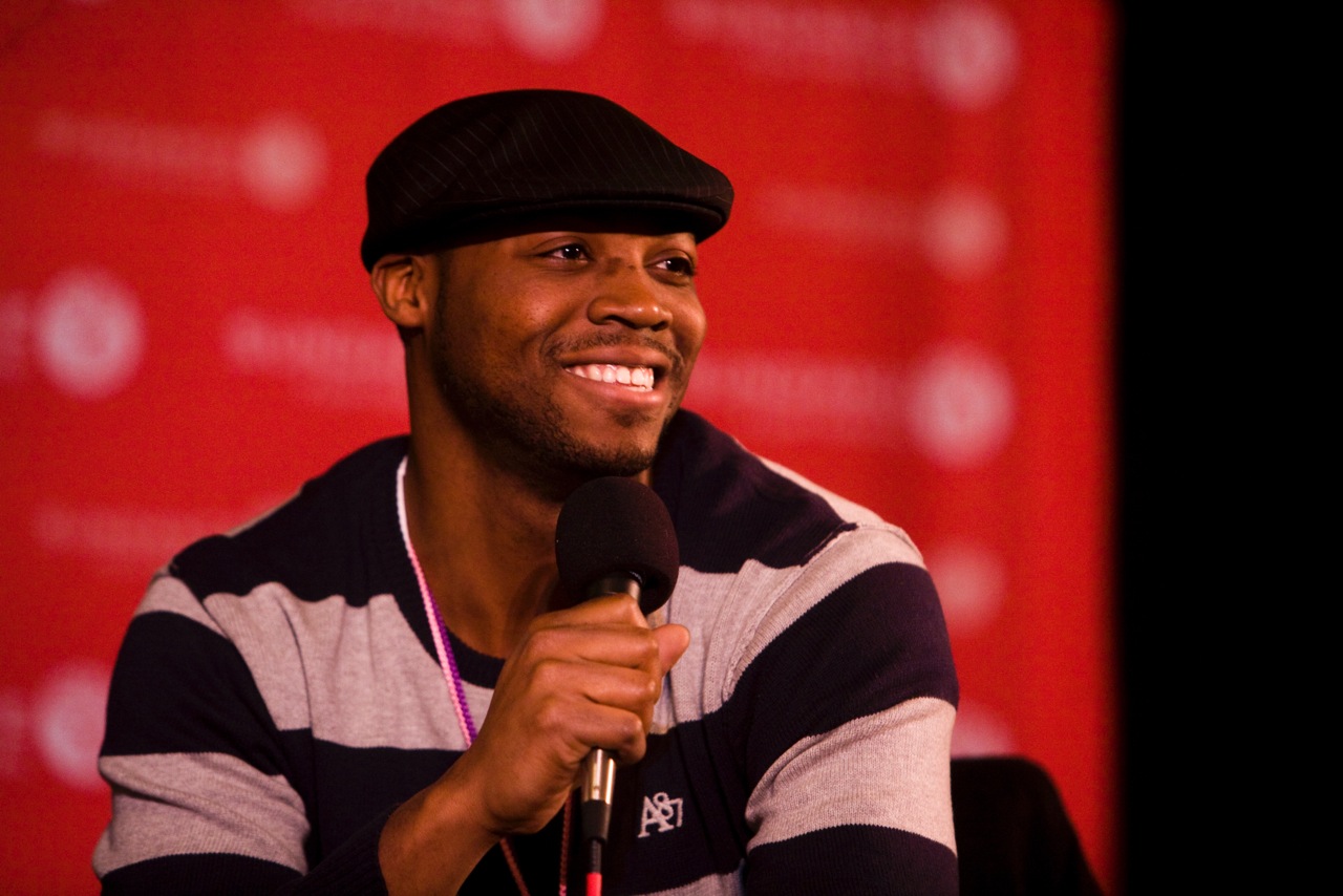 Sultan Sharrief smiling while holding a microphone